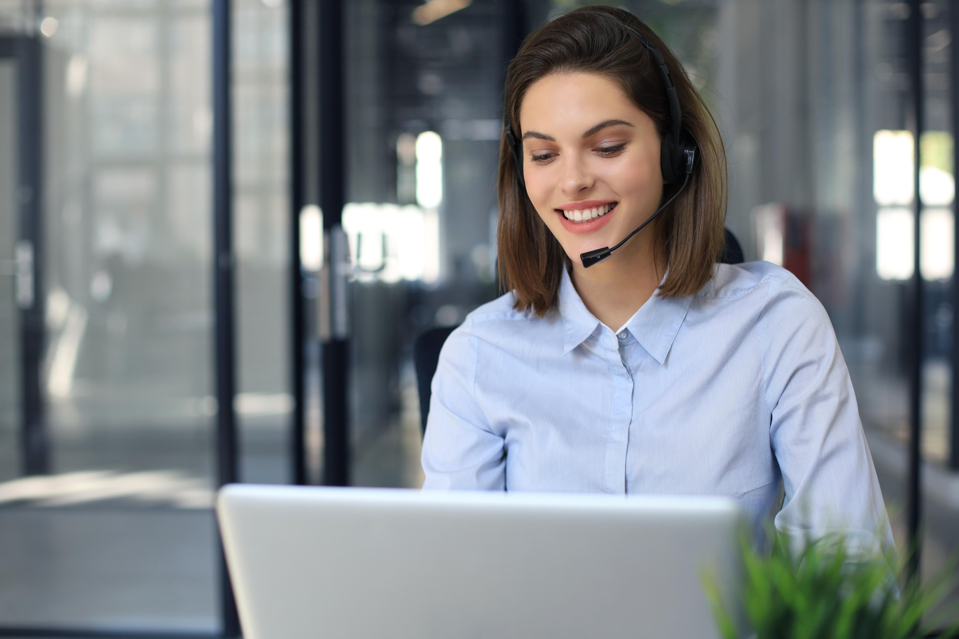 A woman with headphone in front of a computer in a support call. Author: © ty - stock.adobe.com